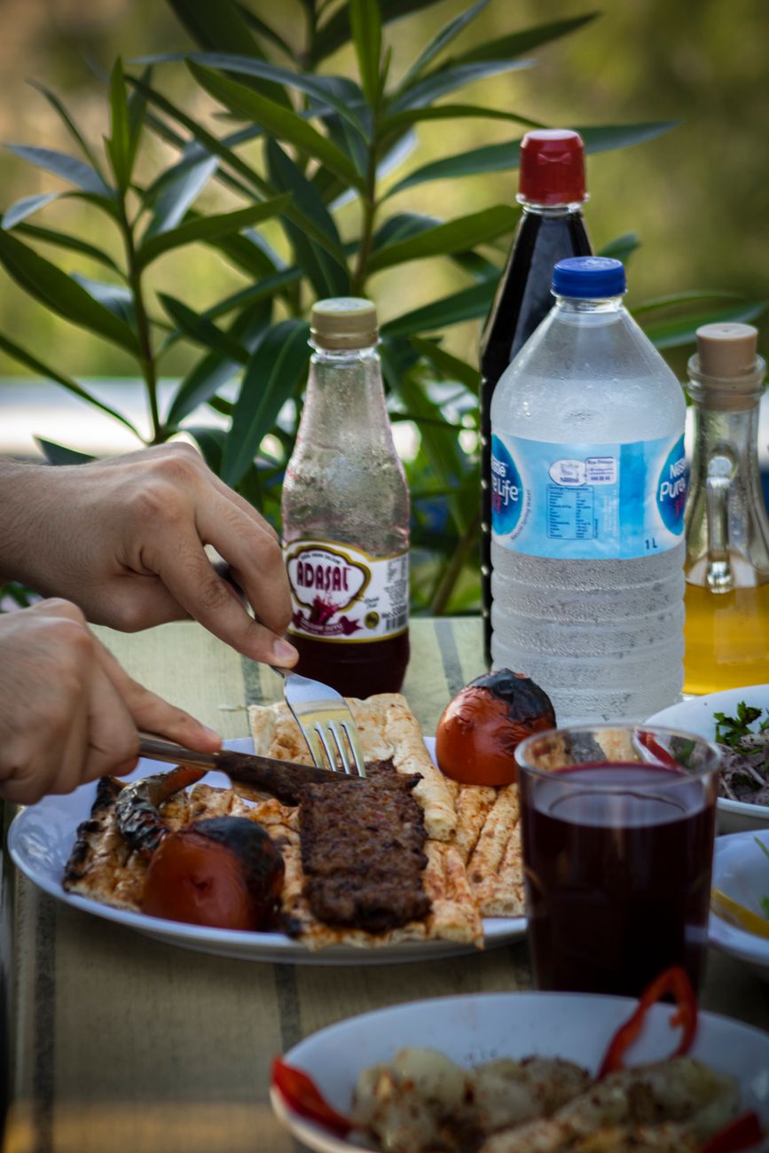 Adana kebap ve Türk yemekleriyle dolu sofrada şalgam suyu — restoranlar için toptan şalgam tedariki